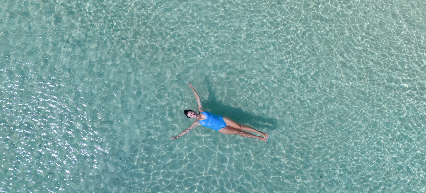 プールに浮かぶ水着の女性
