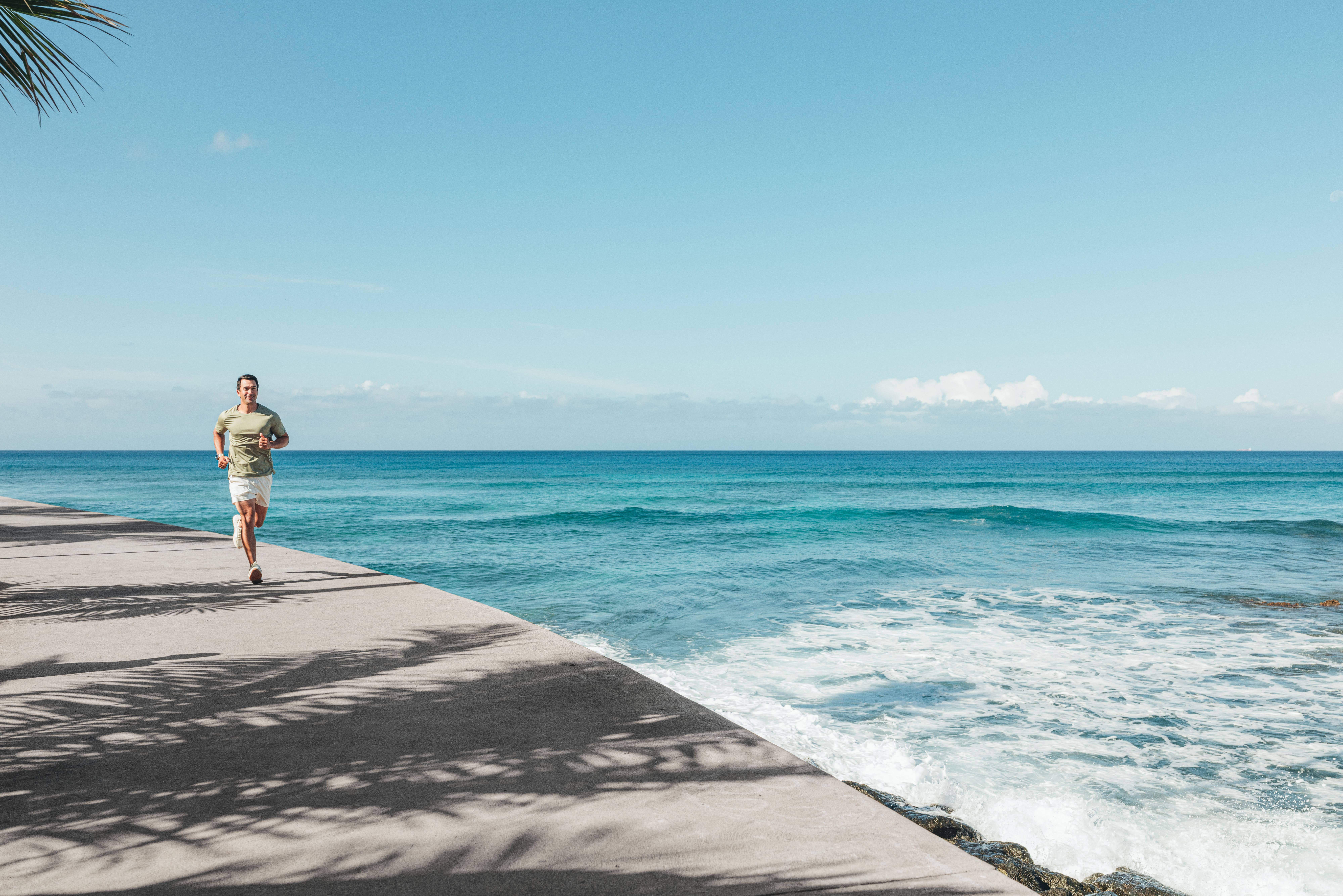 shot of man running near the ocean
